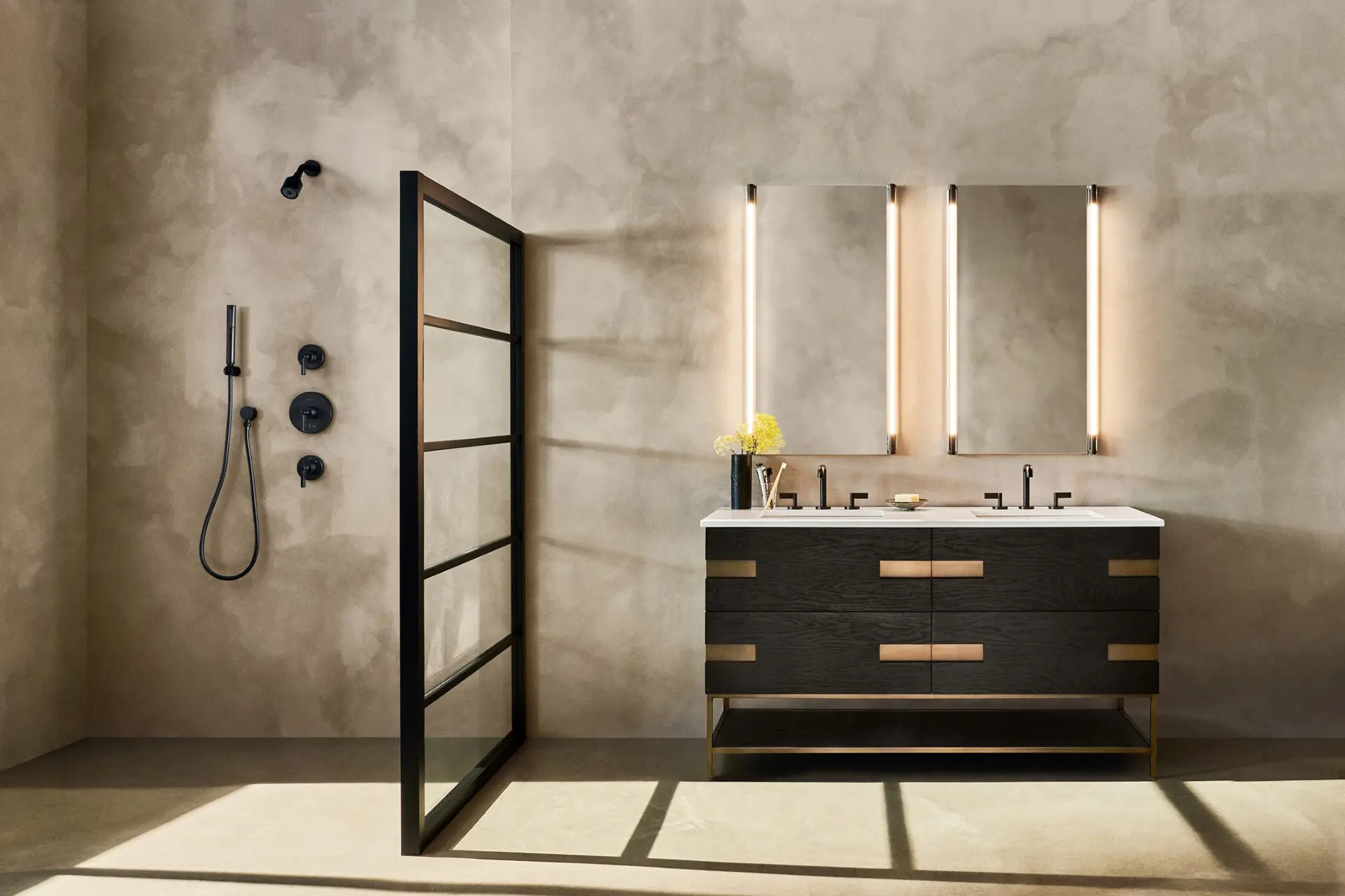 luxury bathroom with black fixtures, black bathroom vanity and lighted bathroom mirrors